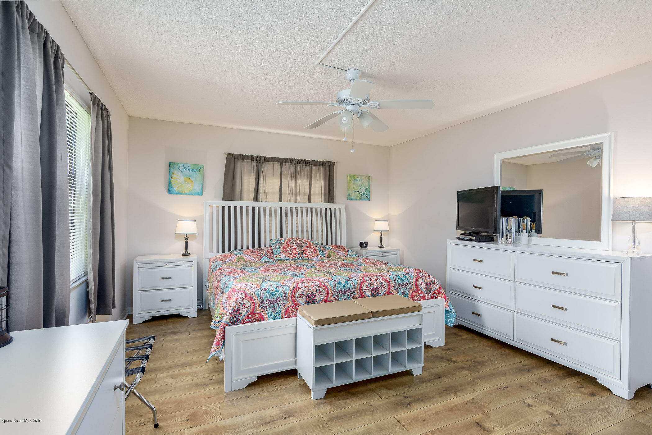 4570 Ocean Beach Boulevard, Unit 106 Cocoa Beach, FL 32931 - Photo 9 of 39 a bedroom with a bed and a dresser in it