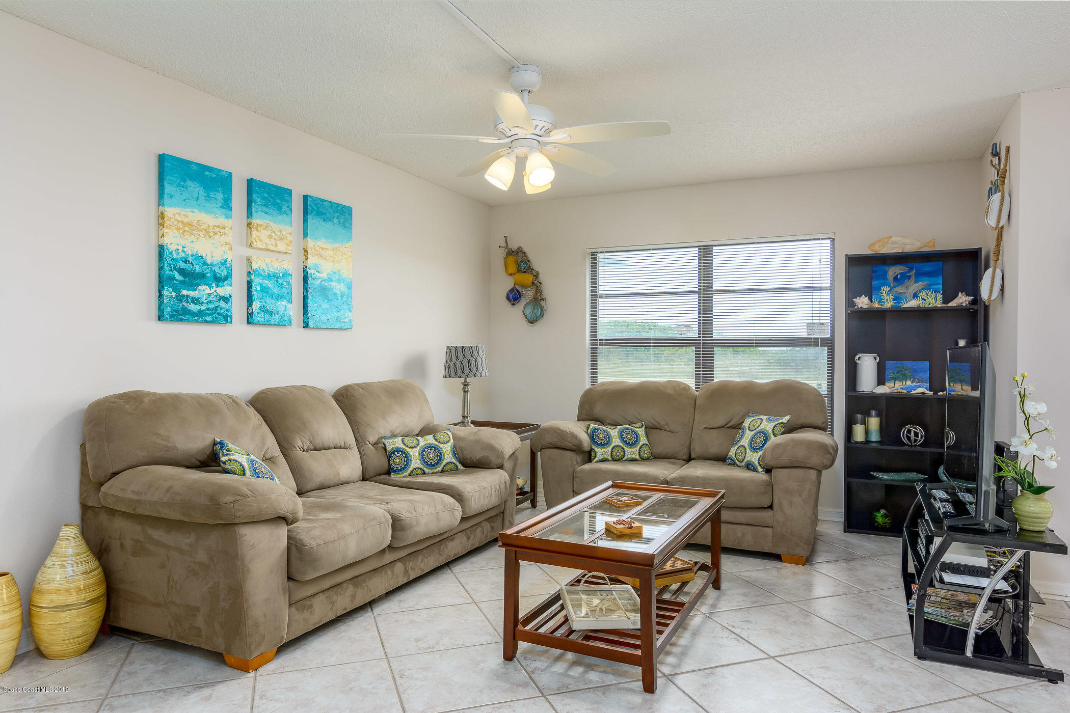 4570 Ocean Beach Boulevard, Unit 106 Cocoa Beach, FL 32931 - Photo 10 of 39 a living room with furniture and a flat screen tv