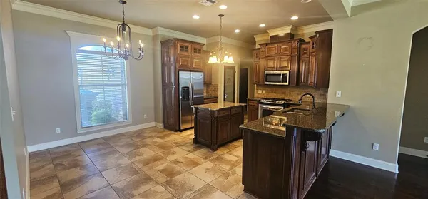 a kitchen with stainless steel appliances granite countertop a refrigerator a sink and a stove