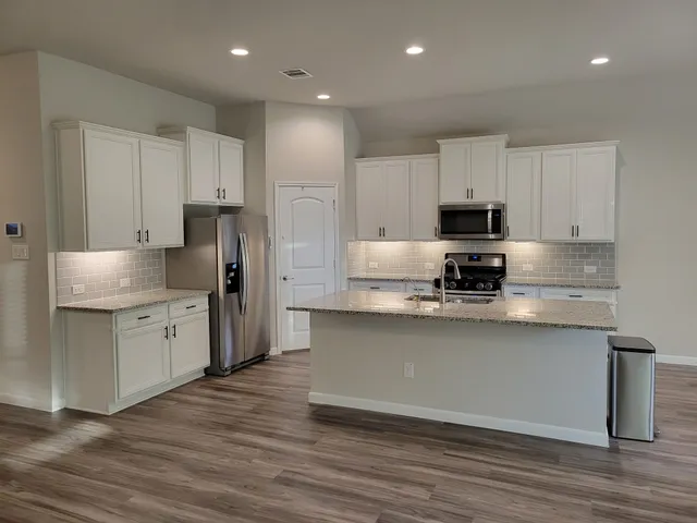 a close view of a sink and dishwasher with wooden floor