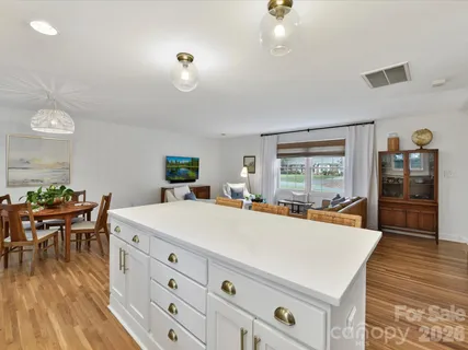 a large white kitchen with wooden floor