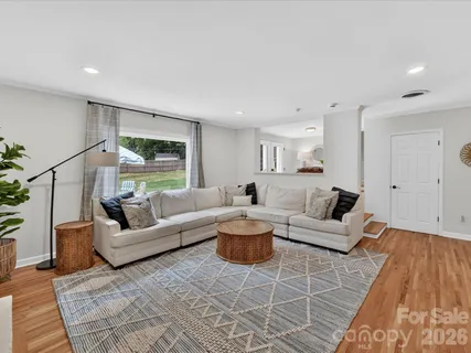 a living room with fireplace furniture and a rug