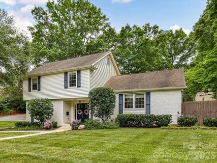 a front view of a house with a yard and green space