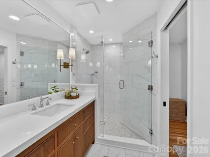 a bathroom with a sink shower and a mirror