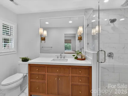 a bathroom with a sink a toilet and shower