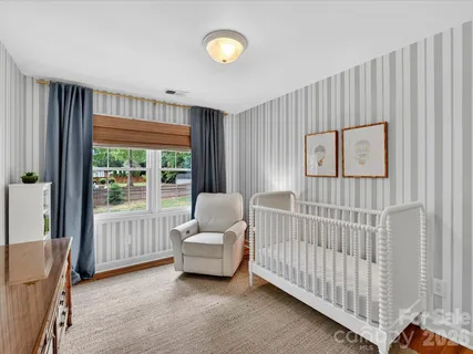 a bedroom with furniture and a large window