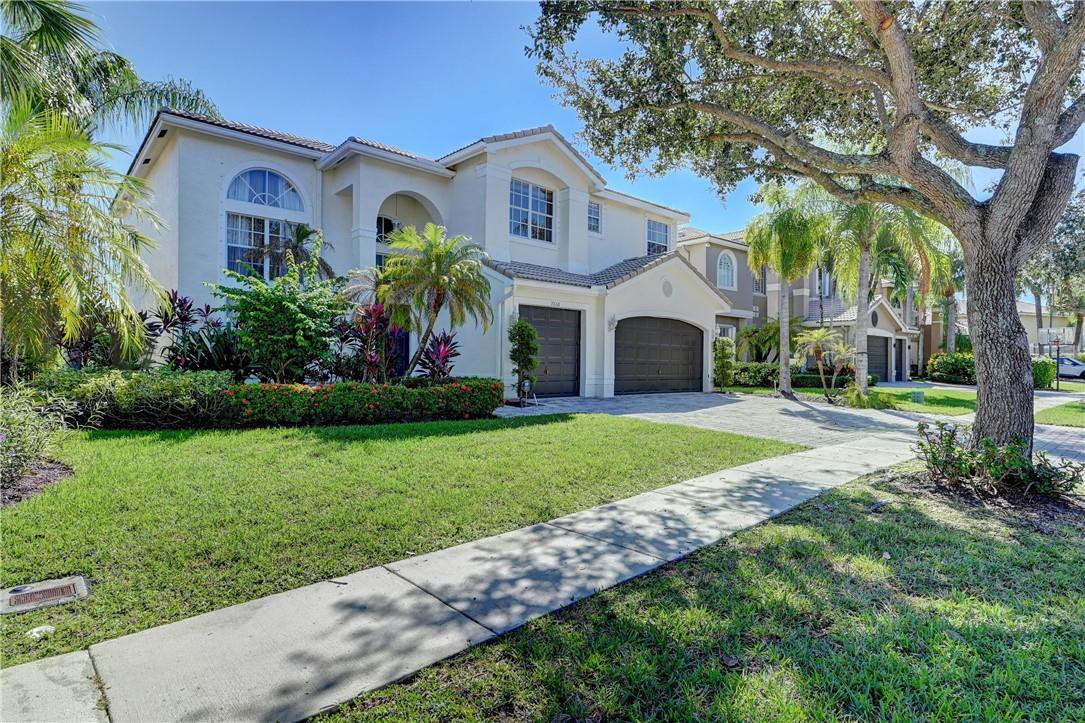 19168 Skyridge Circle Boca Raton, FL 33498 - Photo 2 of 55 a front view of a house with a garden and trees