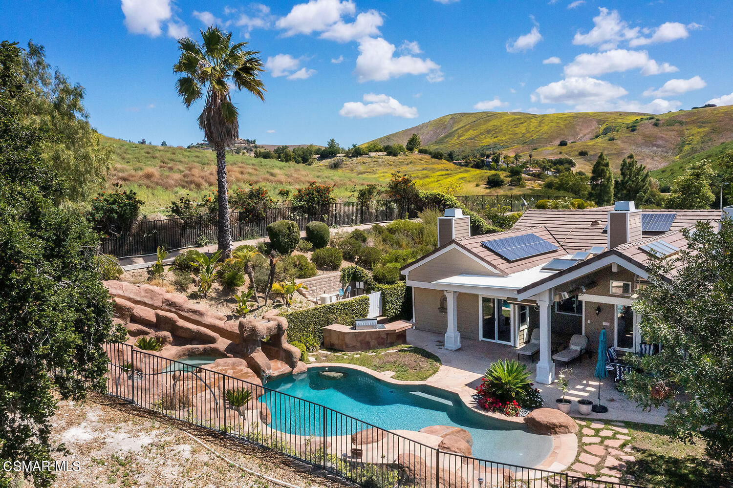 a aerial view of a house with yard swimming pool and outdoor seating