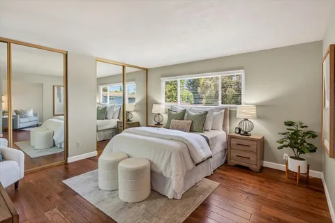a spacious bedroom with a bed and wooden floor