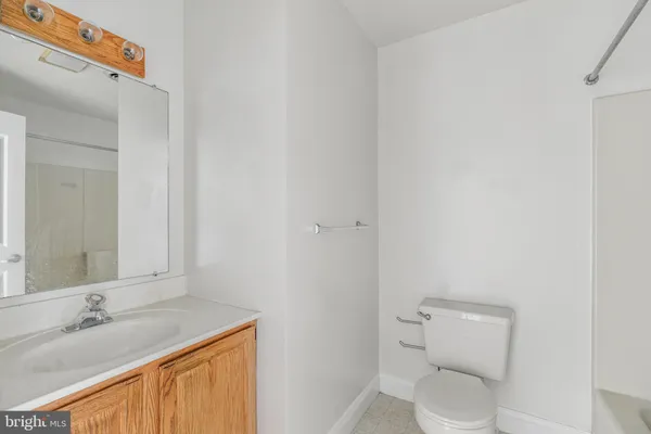 a bathroom with a granite countertop sink and a toilet