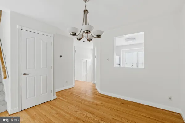 a view of empty room with wooden floor and ceiling fan
