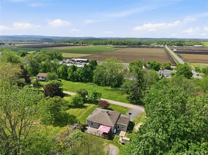an aerial view of a house with a garden and lake view