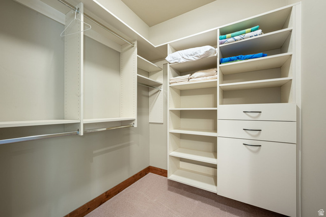 2331 West Entrada Trail, Unit 61 St. George, UT 84770 - Photo 54 of 69 Custom closet system featuring white cabinetry, multiple hanging rods, integrated shelving, and built-in drawers with dark hardware