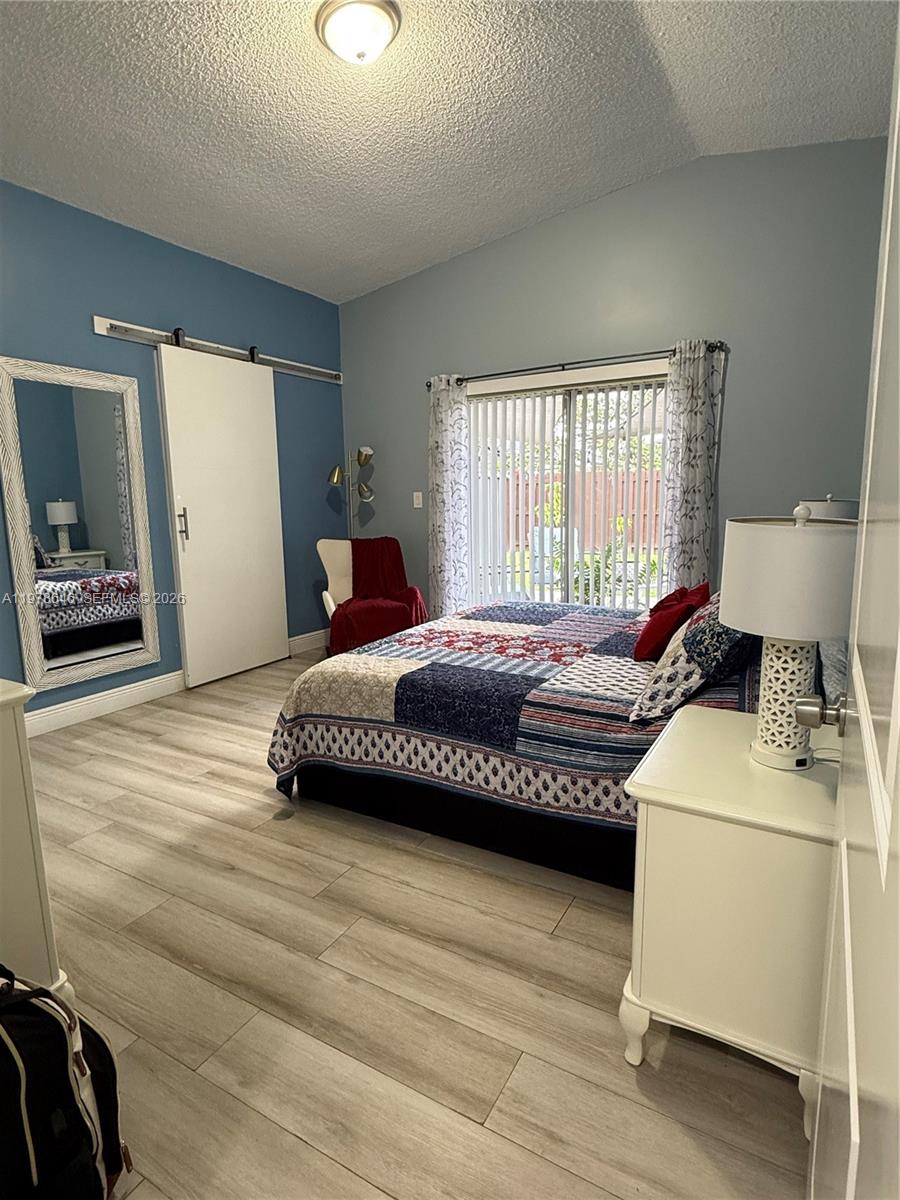 13833 Southwest 157th Street Miami, FL 33177 - Photo 11 of 25 a bedroom with a bed wooden floor and window