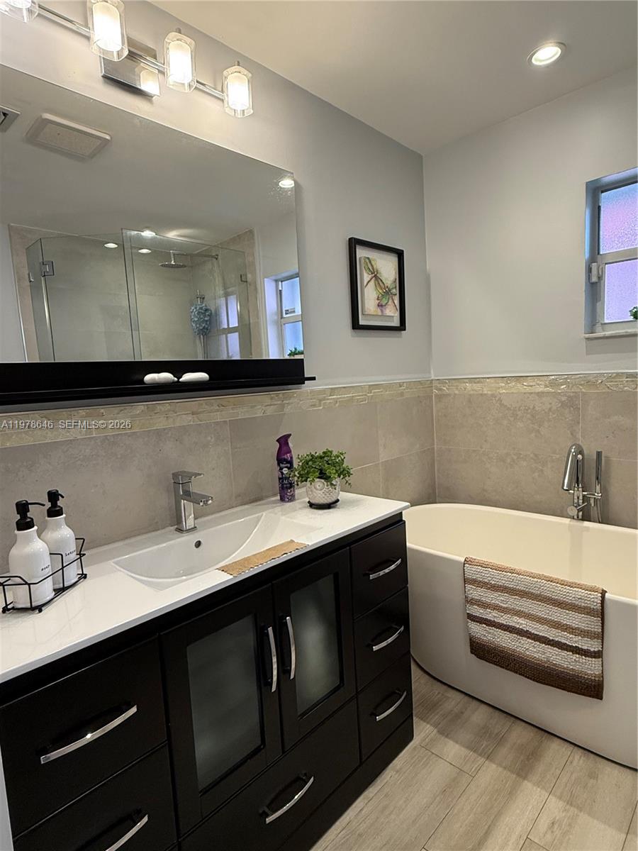 13833 Southwest 157th Street Miami, FL 33177 - Photo 14 of 25 a bathroom with a double vanity sink and a bathtub