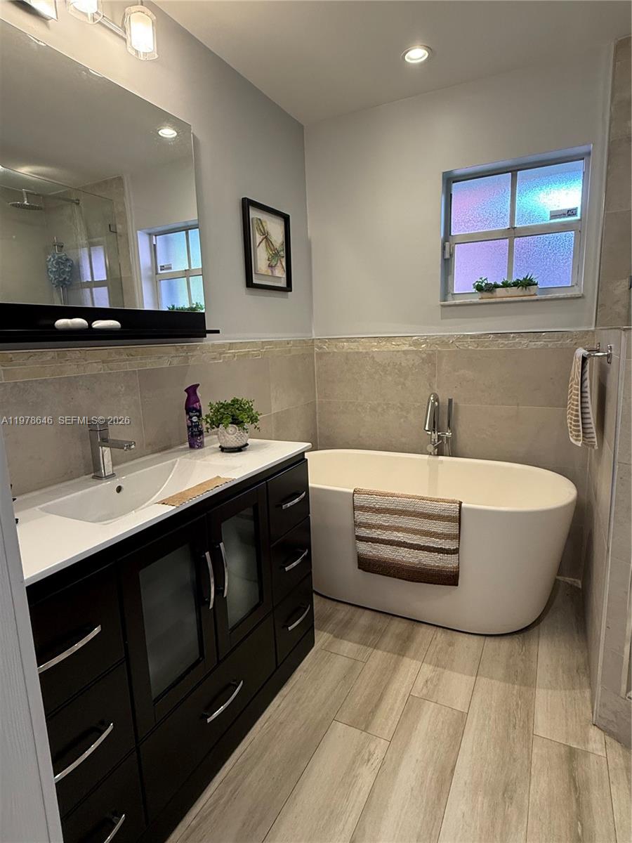 13833 Southwest 157th Street Miami, FL 33177 - Photo 15 of 25 a bathroom with a double vanity sink a mirror and bathtub