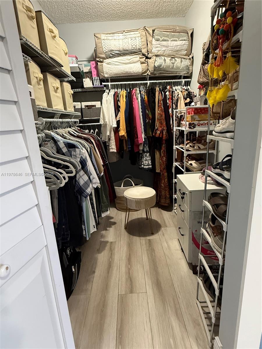 13833 Southwest 157th Street Miami, FL 33177 - Photo 17 of 25 a view of walk in closet with clothes and shoes