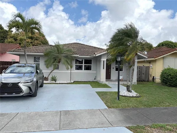 a front view of a house with a garden and plants