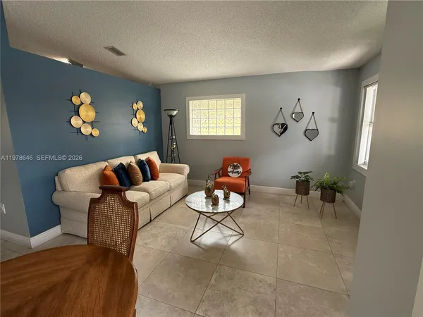a living room with patio furniture and a potted plant
