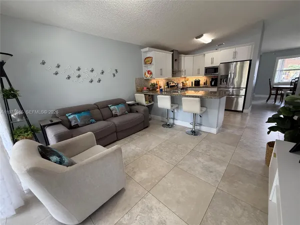 a living room with furniture and kitchen view