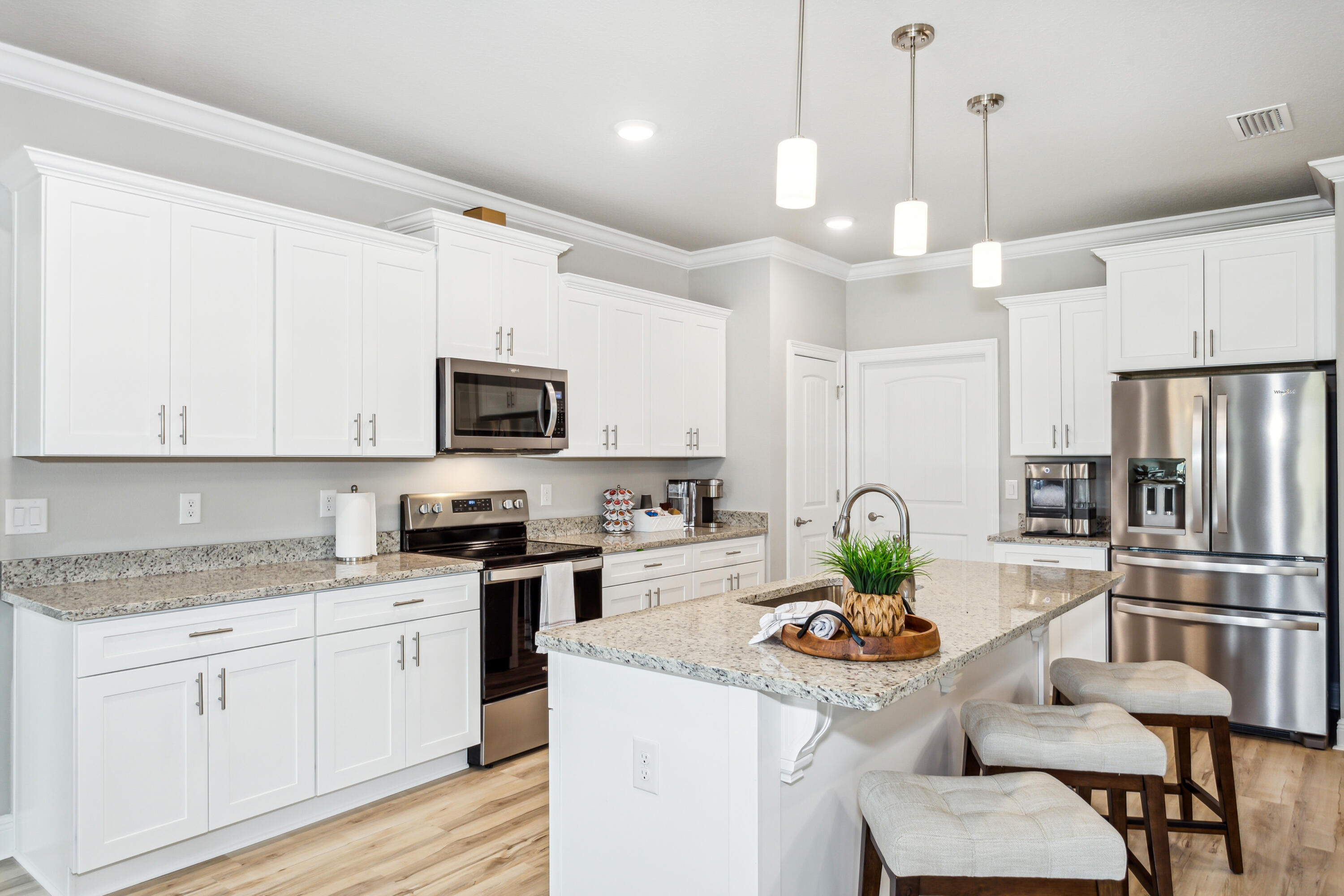 4293 Carl Booker Road Milton, FL 32583 - Photo 17 of 46 a kitchen with stainless steel appliances granite countertop a stove a sink a microwave a refrigerator a dining table and chairs with wooden floor