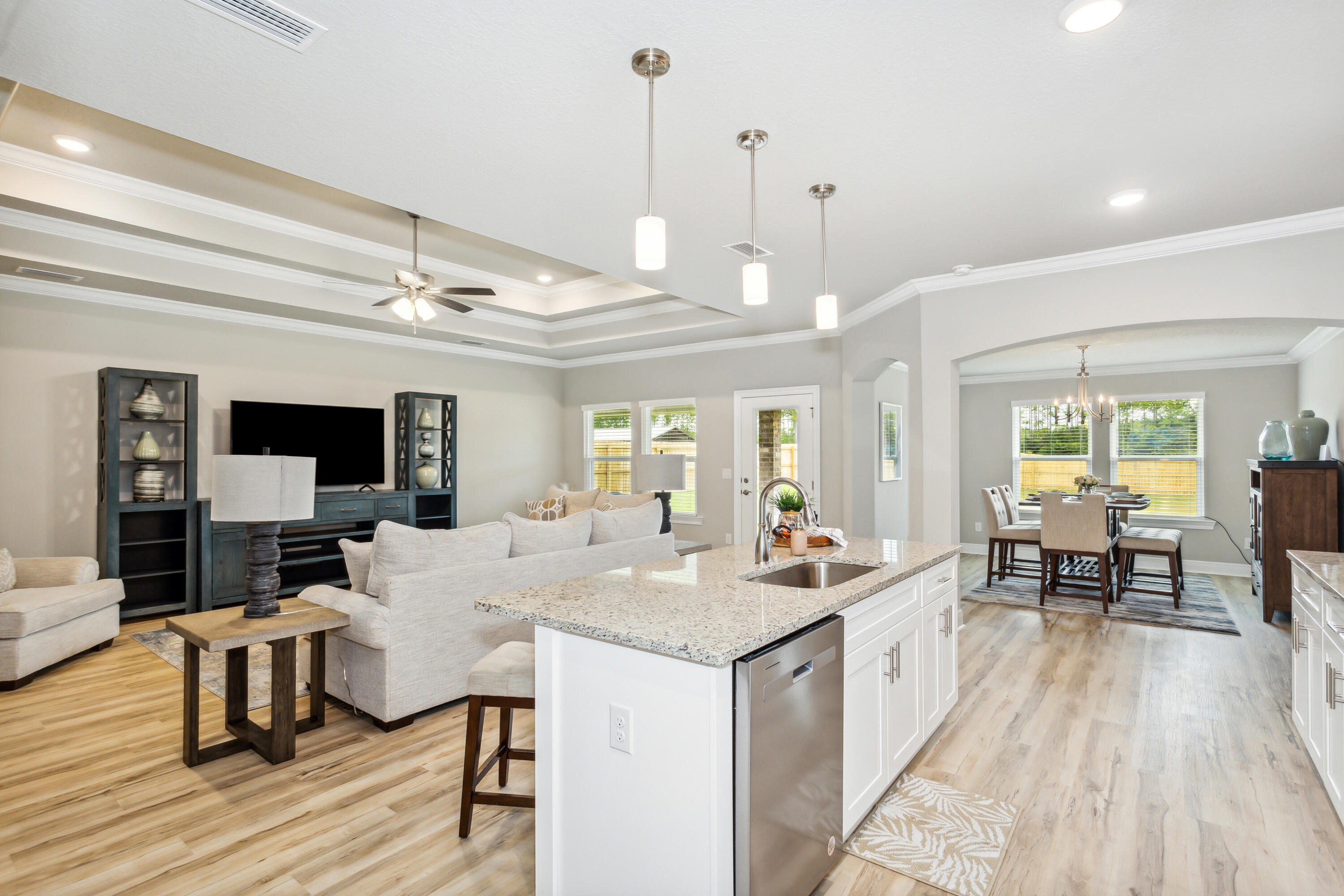 4293 Carl Booker Road Milton, FL 32583 - Photo 20 of 46 a view of a dining room and livingroom with furniture wooden floor a rug a flat screen tv a rug and a chandelier