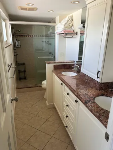 a white toilet sitting next to a bathroom sink and vanity