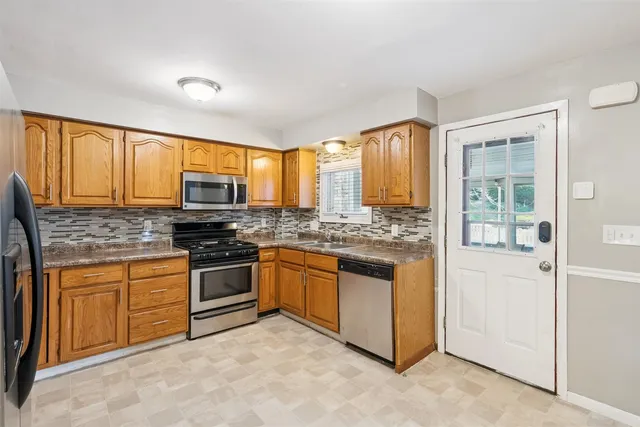 a kitchen with stainless steel appliances granite countertop a stove sink and refrigerator