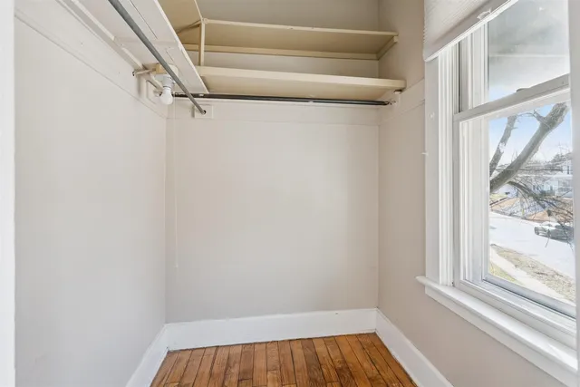 a view of a closet with wooden floor and a window