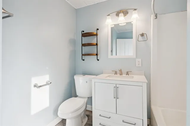 a bathroom with a toilet a sink and mirror