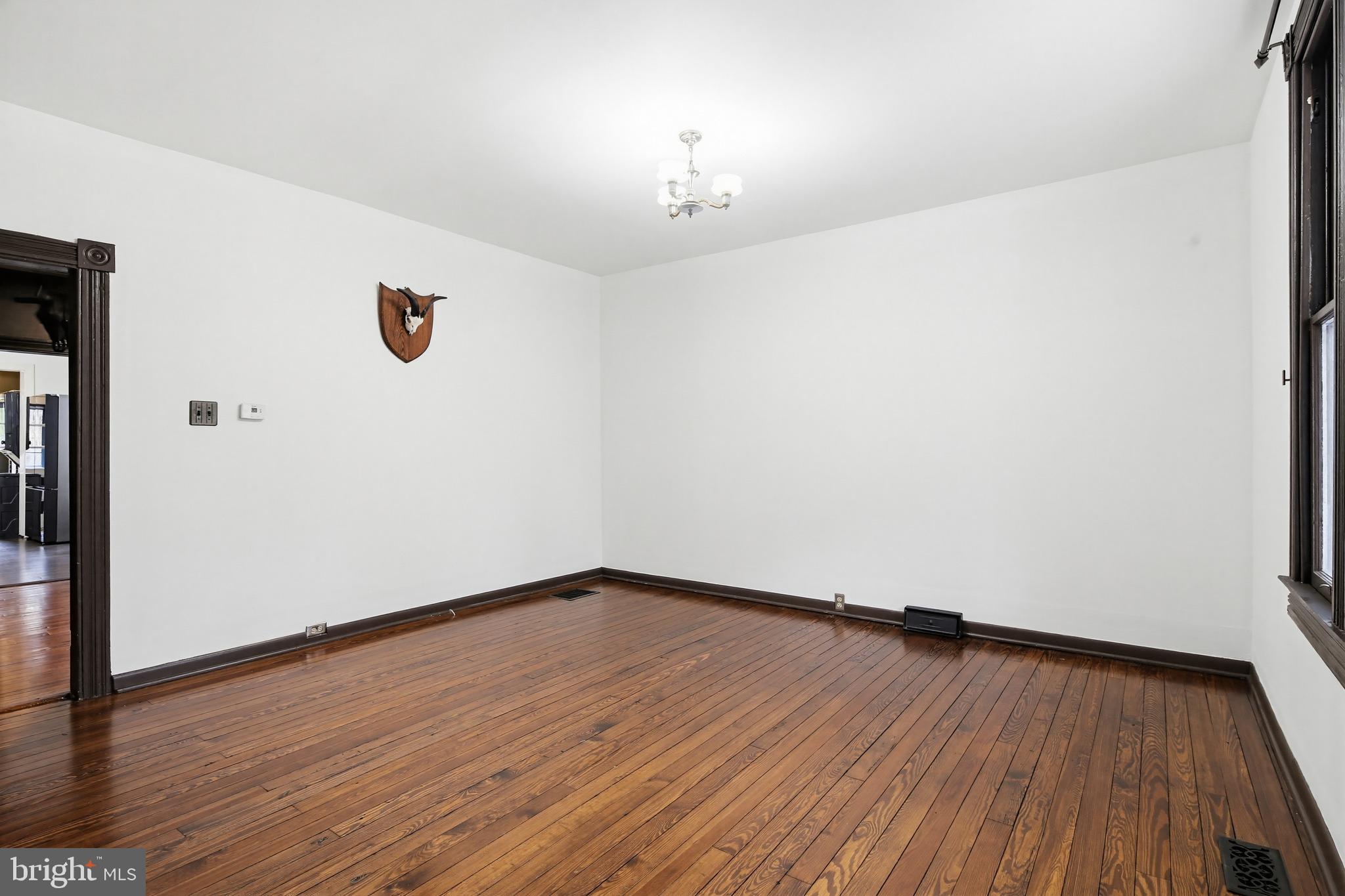 8556 Frederick Road Ellicott City, MD 21043 - Photo 5 of 38 a view of an empty room with wooden floor and a window