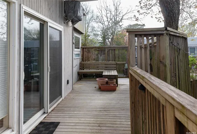 a view of a balcony with chairs and wooden fence