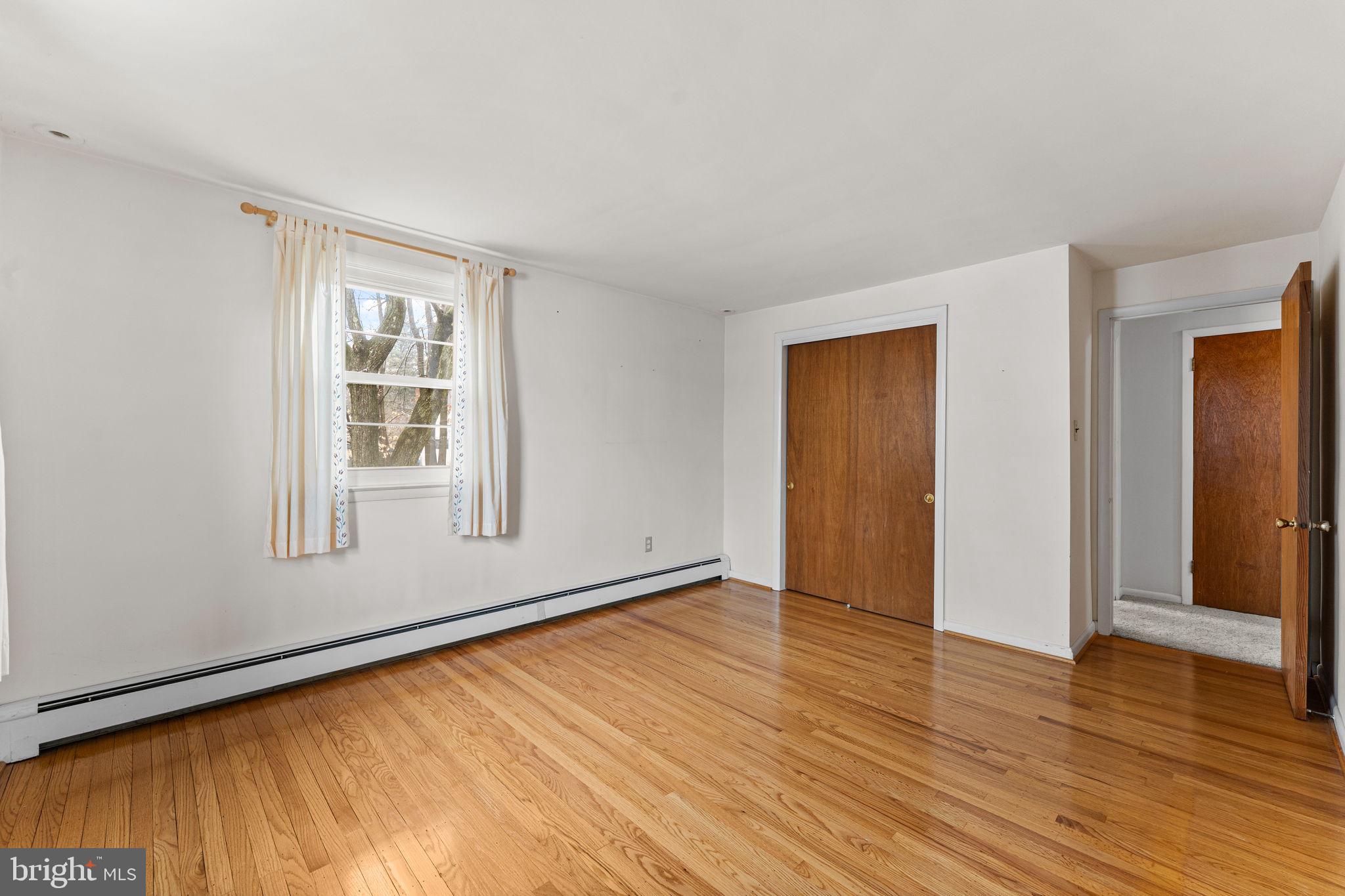 1022 Crozer Lane Springfield, PA 19064 - Photo 21 of 42 an empty room with wooden floor and windows