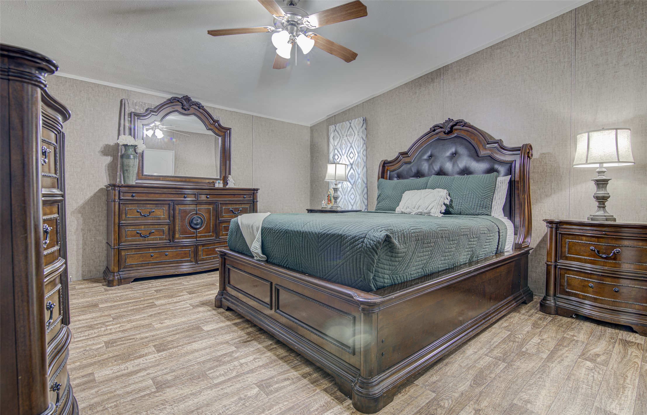 445 Rancho Linda Drive Lockhart, TX 78644 - Photo 17 of 26 Natural light illuminates this bedroom, offering wood-look flooring and a ceiling fan for comfort.