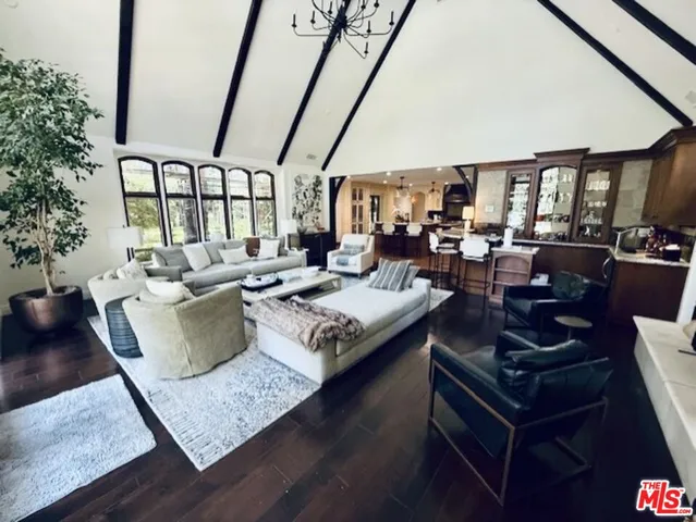 a bedroom with a bed couches and a large window with wooden floor