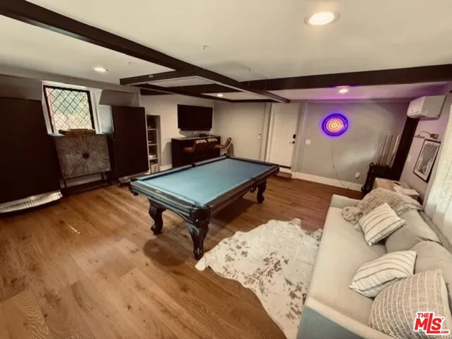 a living room with furniture pool table and a flat screen tv