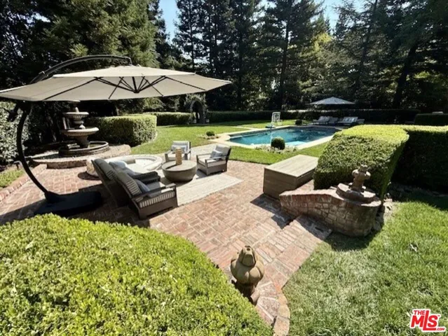 a view of a patio with furniture and a garden