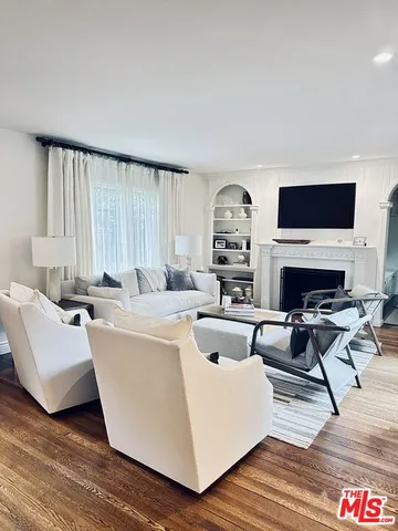 a living room with furniture a fireplace and a flat screen tv