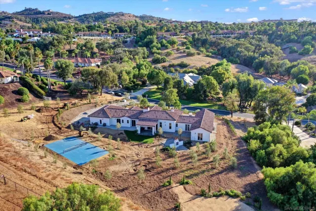 an aerial view of residential houses with outdoor space and trees