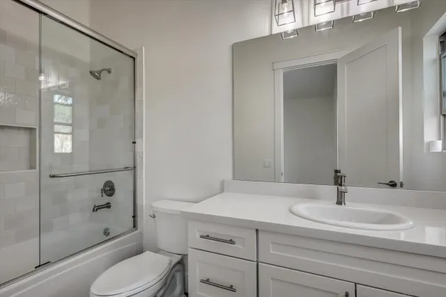 a bathroom with a sink a toilet and shower