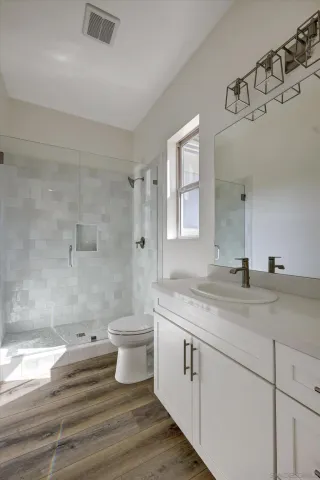 a bathroom with a sink a toilet and shower