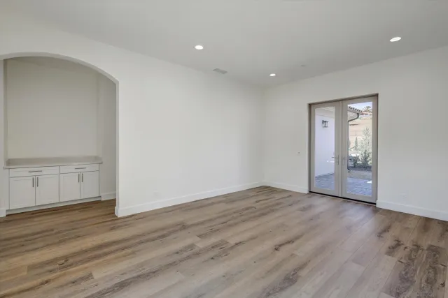 a view of an empty room with wooden floor and closet