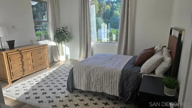 a spacious bedroom with a bed and wooden floor