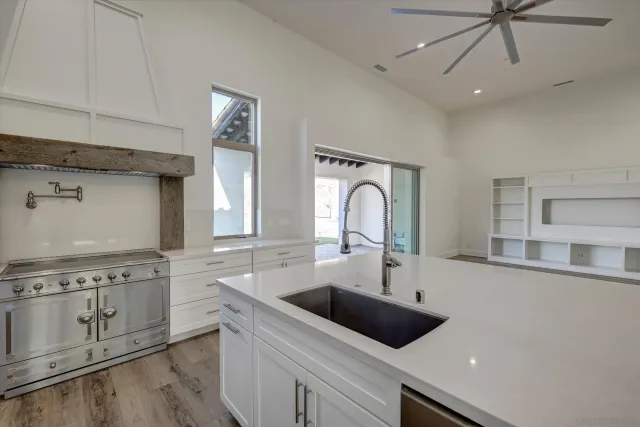 a kitchen with a sink a stove and cabinets