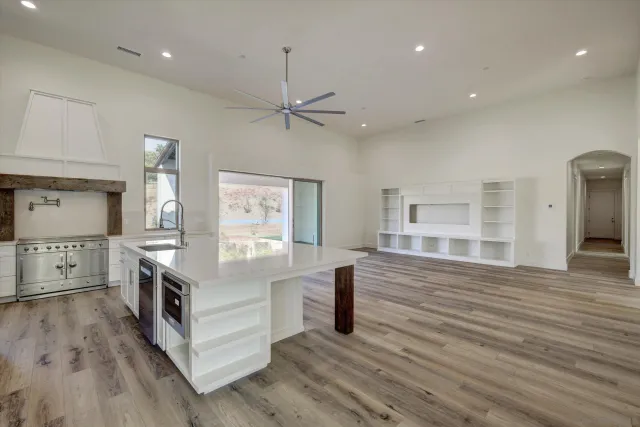 a kitchen with stainless steel appliances granite countertop a oven a stove and a wooden floors