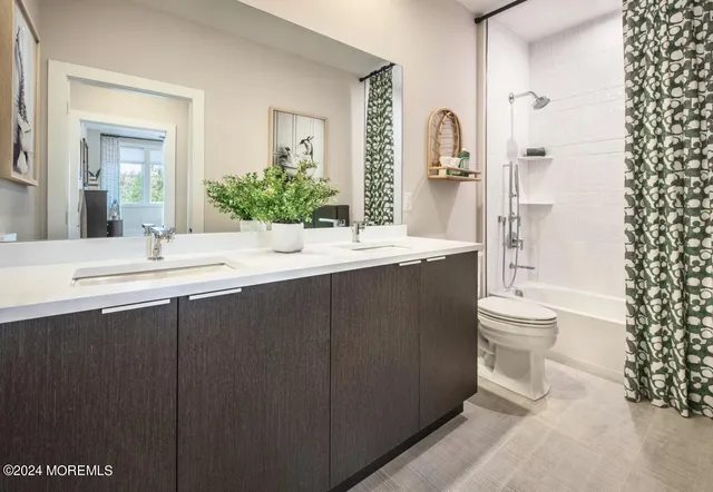 a bathroom with a double vanity sink toilet mirror and shower