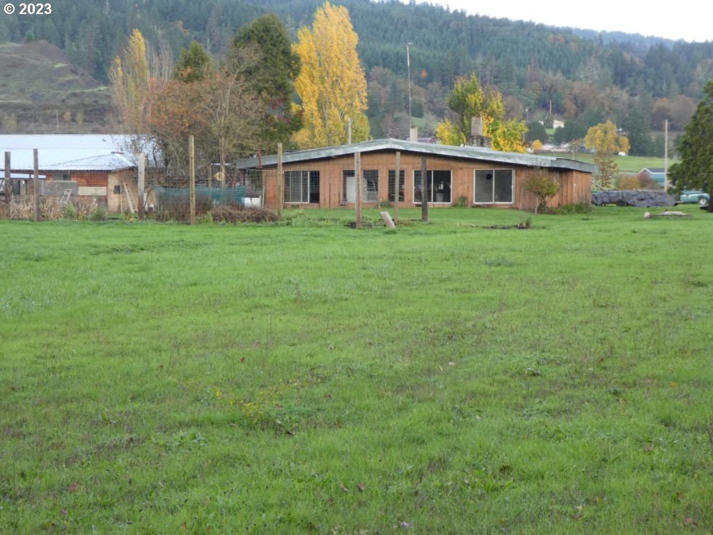 350 Deady Crossing Road Sutherlin, OR 97479 - Photo 3 of 47 a view of a house next to a big yard and large trees