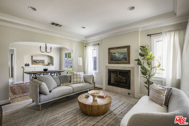 a living room with furniture a fireplace and a window