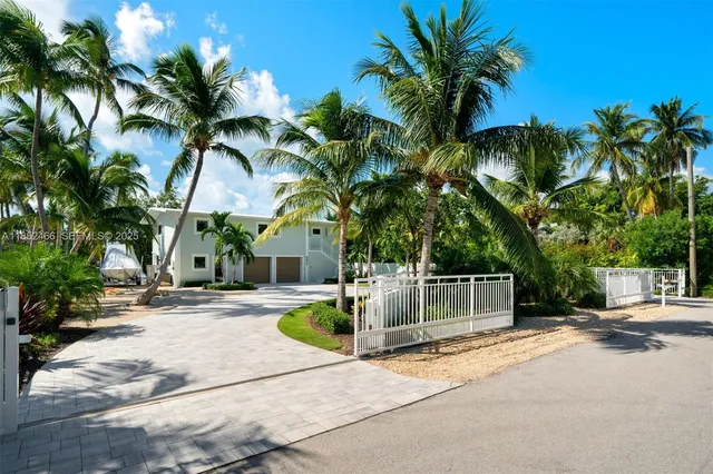 a palm tree sitting in front of a house with a patio