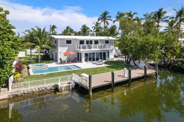 a view of a swimming pool with a table and chairs under an umbrella